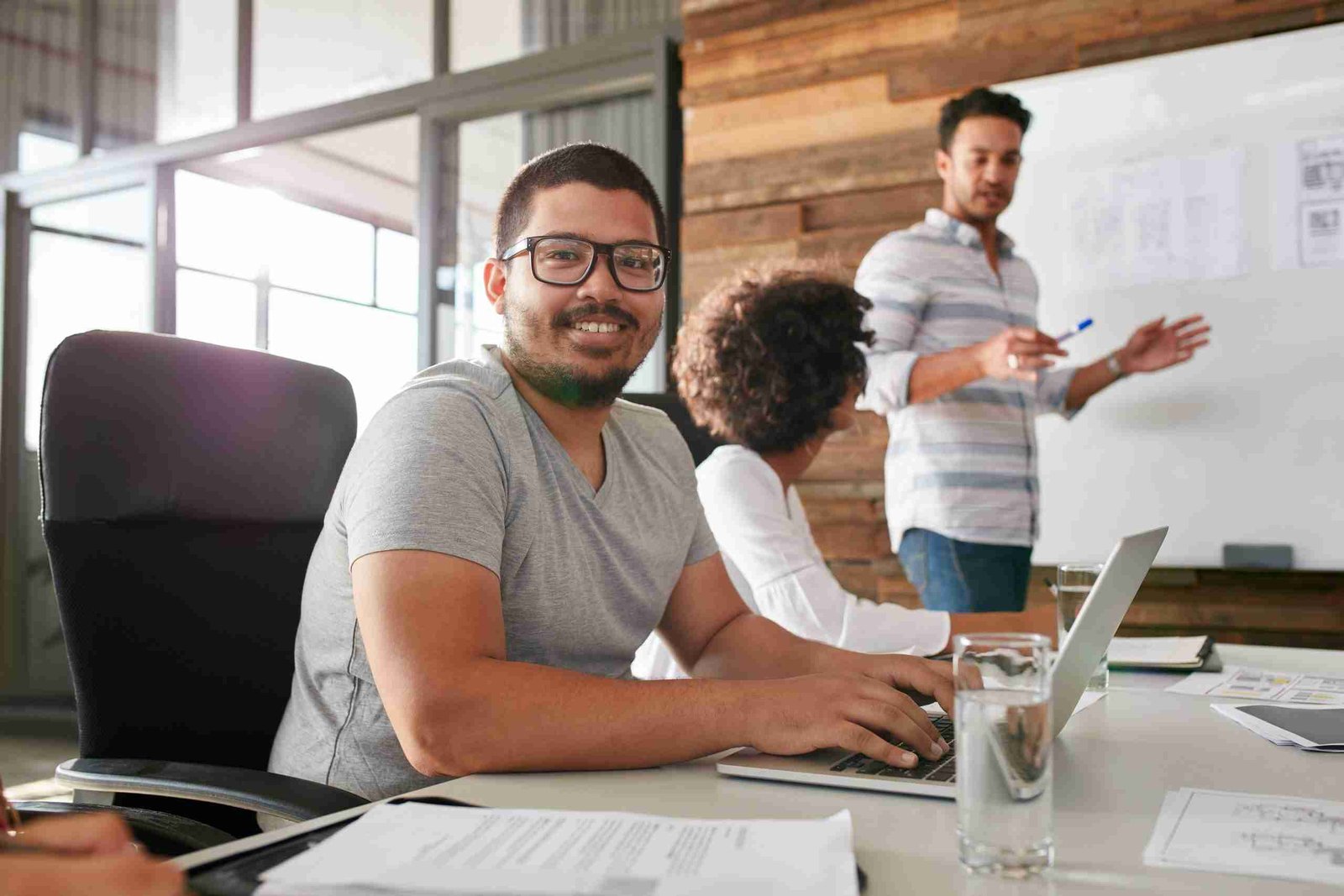 Smiling young man sitting at a business meeting with colleagues